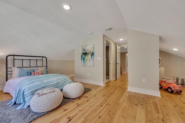 bedroom featuring light hardwood / wood-style floors and lofted ceiling