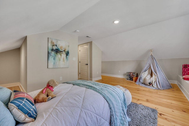 bedroom with wood-type flooring and vaulted ceiling