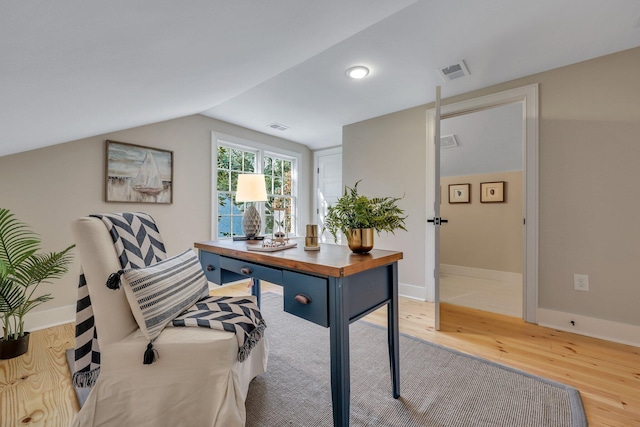 home office with lofted ceiling and light hardwood / wood-style flooring