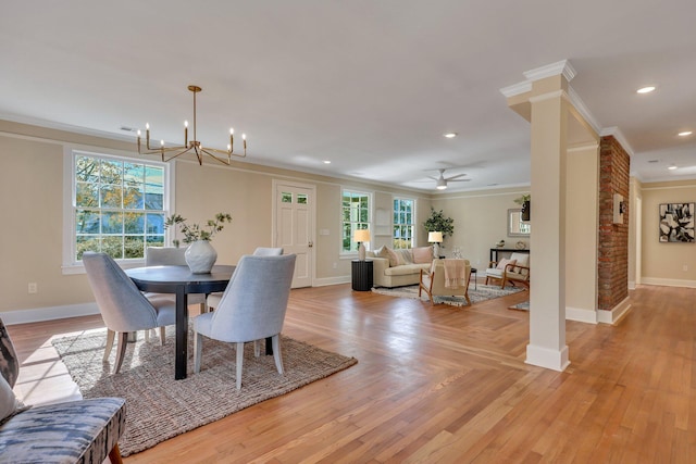 dining room with ornate columns, light hardwood / wood-style flooring, ceiling fan with notable chandelier, and ornamental molding