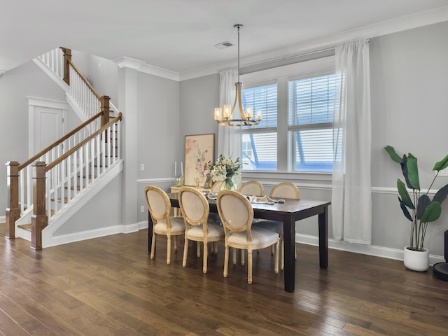 dining area featuring dark hardwood / wood-style flooring, crown molding, and a chandelier