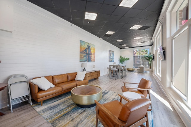 living room with a paneled ceiling and wood finished floors