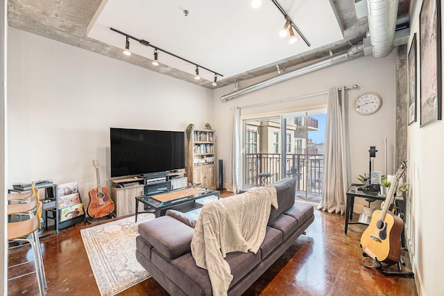 living room with finished concrete floors and track lighting