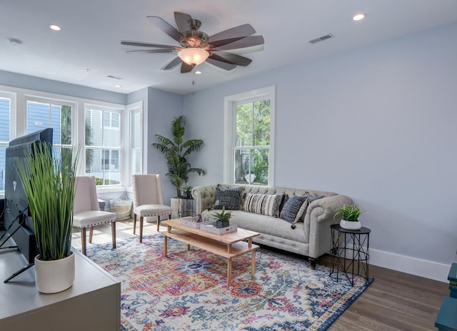 living room with dark hardwood / wood-style flooring and ceiling fan