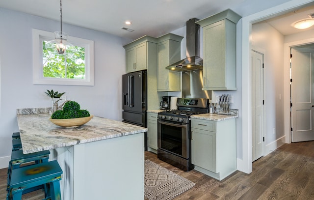 kitchen featuring light stone counters, wall chimney exhaust hood, stainless steel gas range oven, high quality fridge, and dark hardwood / wood-style floors