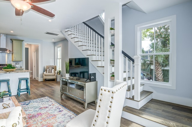 stairs with wood-type flooring and ceiling fan