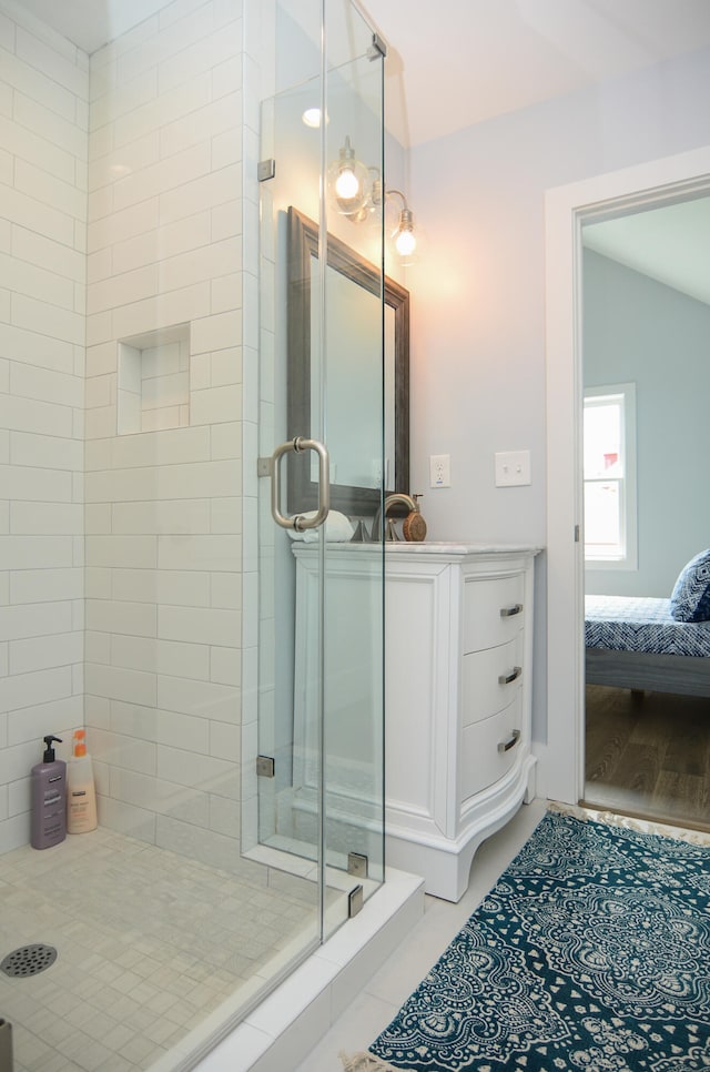 bathroom with a shower with door, vaulted ceiling, and hardwood / wood-style flooring