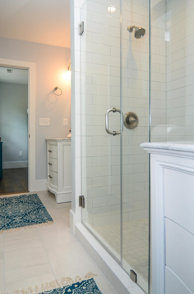 bathroom featuring vanity, a shower with shower door, and tile patterned floors