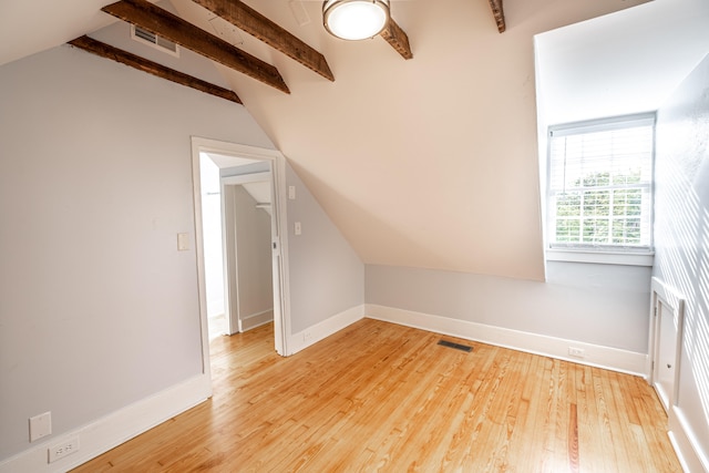 bonus room featuring light wood-type flooring and lofted ceiling with beams