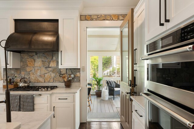 1012 Ashley Ave, Charleston, SC 29403 - kitchen with white cabinetry, ornamental molding, decorative backsplash, and custom range hood