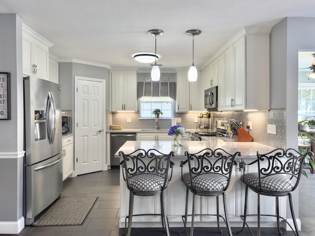 482 Planters Trace Dr, Charleston, SC 29412 - kitchen featuring appliances with stainless steel finishes, a peninsula, plenty of natural light, backsplash, and ornamental molding