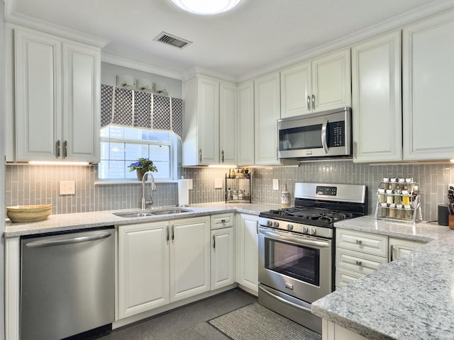 482 Planters Trace Dr, Charleston, SC 29412 - kitchen with appliances with stainless steel finishes, a sink, backsplash, white cabinets, and light stone countertops