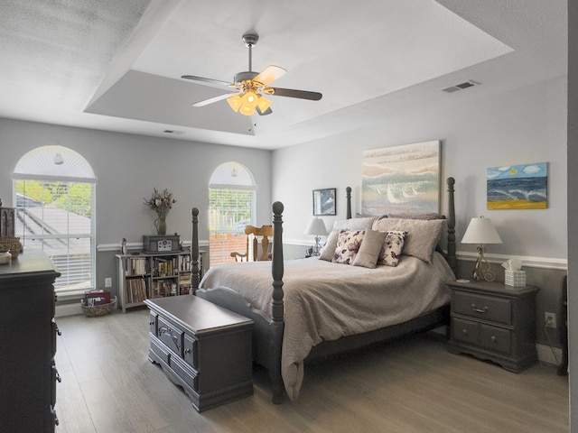 482 Planters Trace Dr, Charleston, SC 29412 - bedroom featuring a raised ceiling, wood finished floors, multiple windows, and a ceiling fan