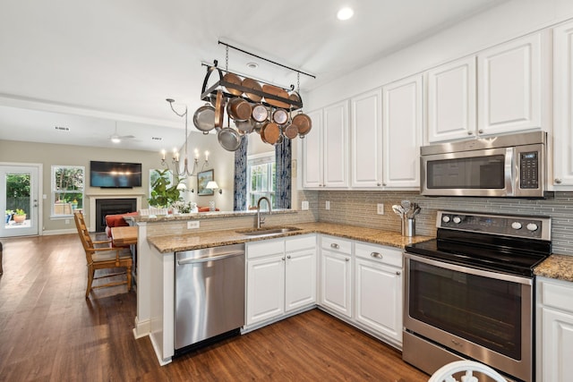 708 Lawton Harbor Dr, Charleston, SC 29412 - kitchen with appliances with stainless steel finishes, a peninsula, dark wood finished floors, tasteful backsplash, and recessed lighting