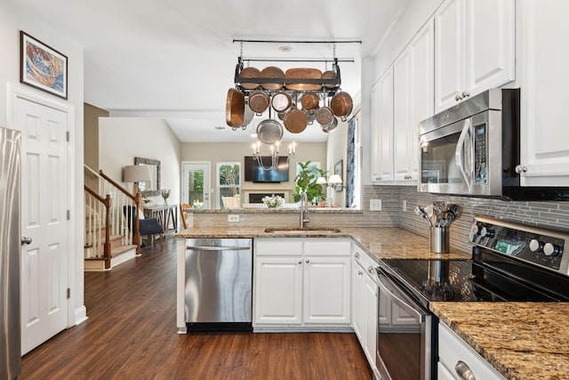 708 Lawton Harbor Dr, Charleston, SC 29412 - kitchen with stainless steel appliances, tasteful backsplash, a peninsula, white cabinetry, and dark wood-style flooring