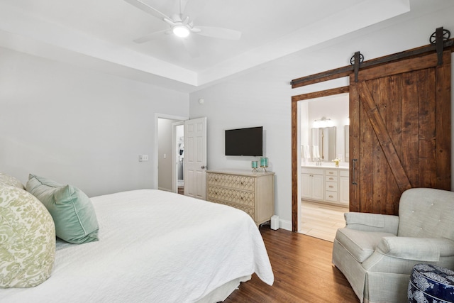 708 Lawton Harbor Dr, Charleston, SC 29412 - bedroom featuring dark wood finished floors, a raised ceiling, ensuite bathroom, a ceiling fan, and a barn door
