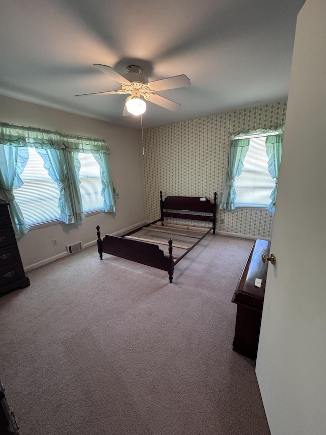 686 W Pine St, Varnville, SC 29944 - carpeted bedroom featuring multiple windows, wallpapered walls, and ceiling fan
