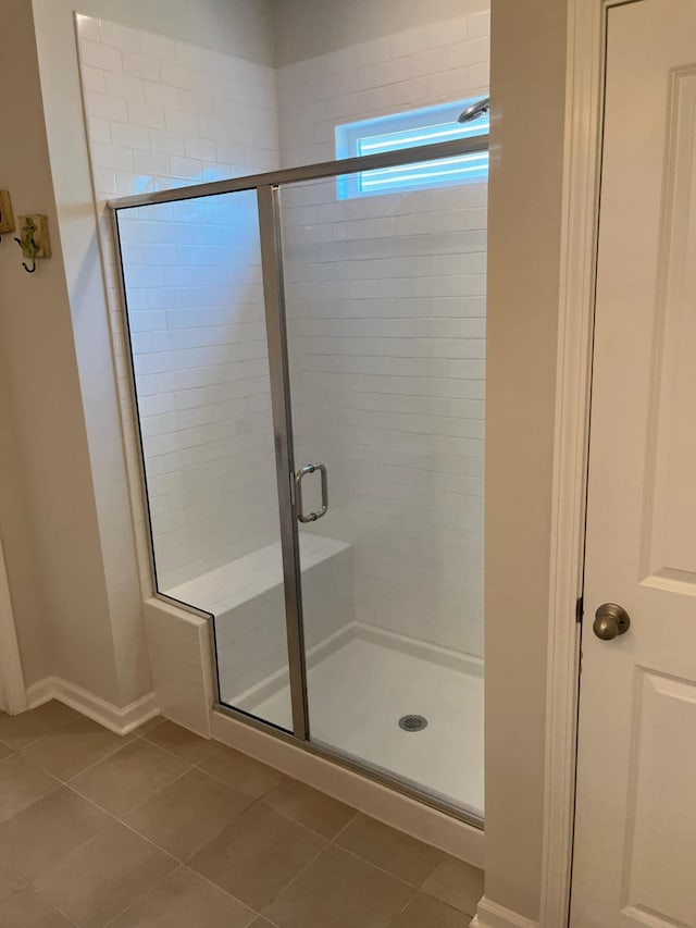 full bath with tile patterned floors, a stall shower, and baseboards