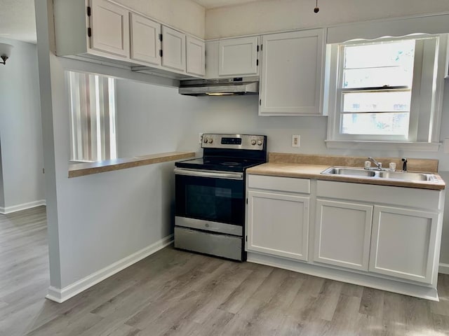105 S Merriman Rd, Georgetown, SC 29440 - kitchen with electric stove, under cabinet range hood, light wood-type flooring, white cabinets, and light countertops