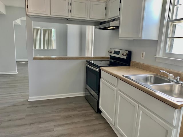 105 S Merriman Rd, Georgetown, SC 29440 - kitchen with electric range, under cabinet range hood, light wood-style flooring, white cabinets, and light countertops