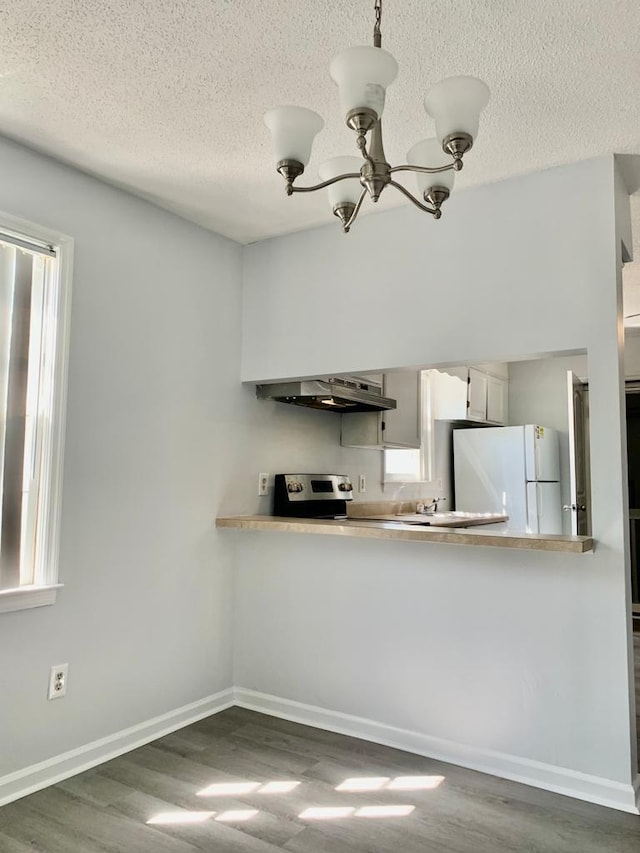 105 S Merriman Rd, Georgetown, SC 29440 - kitchen with freestanding refrigerator, extractor fan, a chandelier, a textured ceiling, and wood finished floors