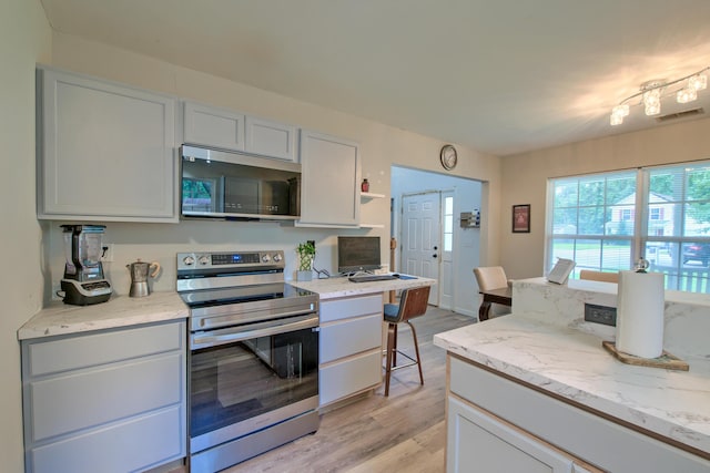 2538 Wayne Scott Ct, Charleston, SC 29414 - kitchen with stainless steel appliances, light wood-type flooring, open shelves, and light stone counters
