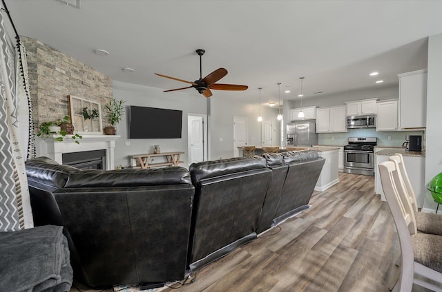 111 Nolin Rd, Moncks Corner, SC 29461 - living room with a ceiling fan, light wood-style flooring, a glass covered fireplace, and recessed lighting