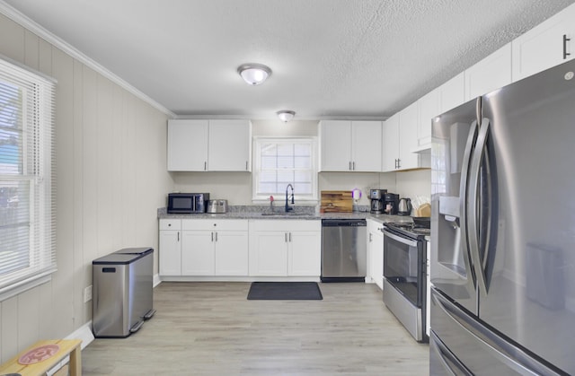 3428 Plaza Ln, North Charleston, SC 29420 - kitchen with appliances with stainless steel finishes, a sink, white cabinetry, light wood finished floors, and ornamental molding