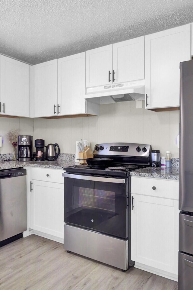 3428 Plaza Ln, North Charleston, SC 29420 - kitchen with stainless steel appliances, under cabinet range hood, light wood-type flooring, white cabinets, and a textured ceiling