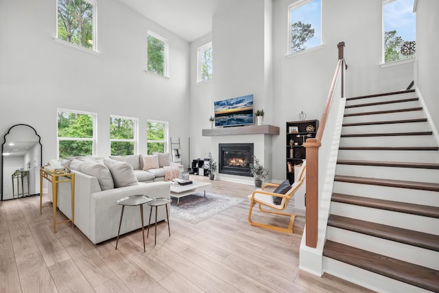 1387 Thin Pine Dr, Johns Island, SC 29455 - living area featuring a towering ceiling, a glass covered fireplace, stairs, and light wood finished floors