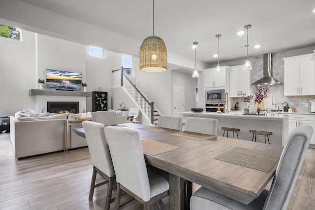 1387 Thin Pine Dr, Johns Island, SC 29455 - dining space with stairs, light wood-style flooring, recessed lighting, and a glass covered fireplace
