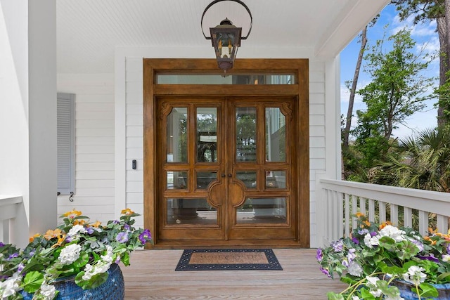 doorway to property with covered porch and french doors