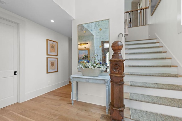 stairway featuring wood finished floors, baseboards, and recessed lighting