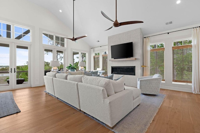 living area with a ceiling fan, recessed lighting, visible vents, and a large fireplace