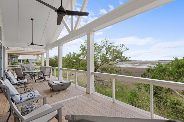wooden terrace with a ceiling fan and outdoor dining space