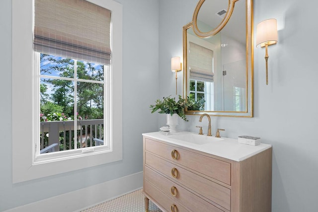 bathroom with a wealth of natural light, visible vents, baseboards, and vanity