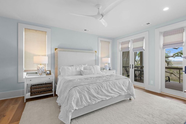 bedroom with baseboards, visible vents, wood finished floors, and access to exterior