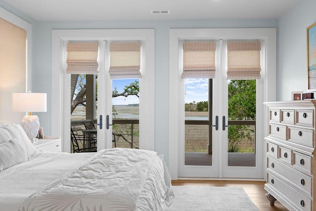 bedroom featuring french doors, visible vents, wood finished floors, and access to exterior