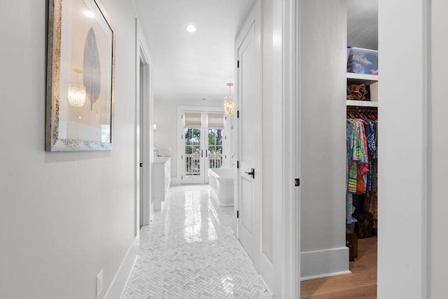 hall with baseboards and recessed lighting