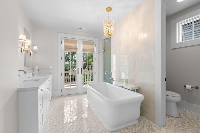 full bath featuring french doors, an inviting chandelier, visible vents, a sink, and double vanity