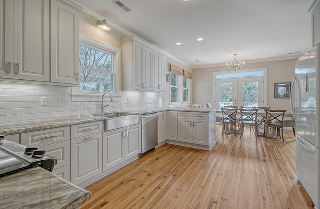 kitchen with fridge, decorative light fixtures, dishwasher, and white cabinets