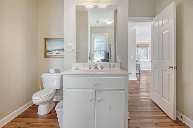 bathroom featuring wood-type flooring, vanity, and toilet