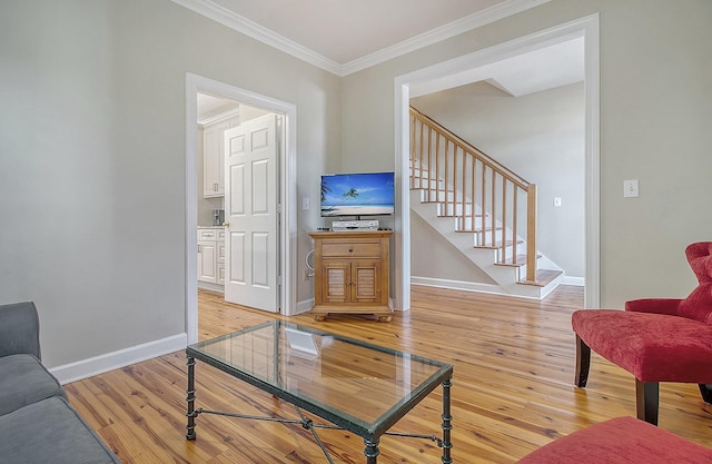 living room with ornamental molding and light hardwood / wood-style flooring