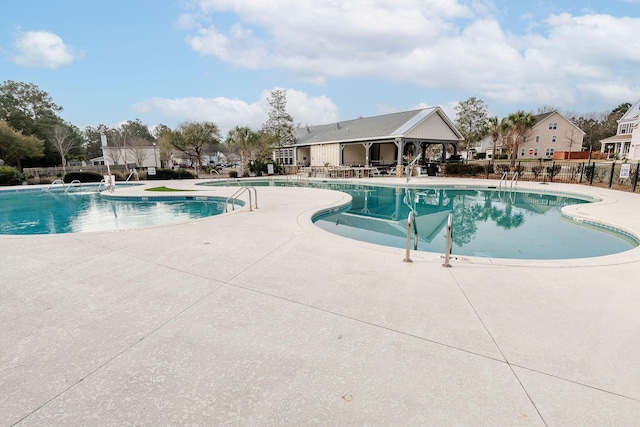 pool with a patio area and fence