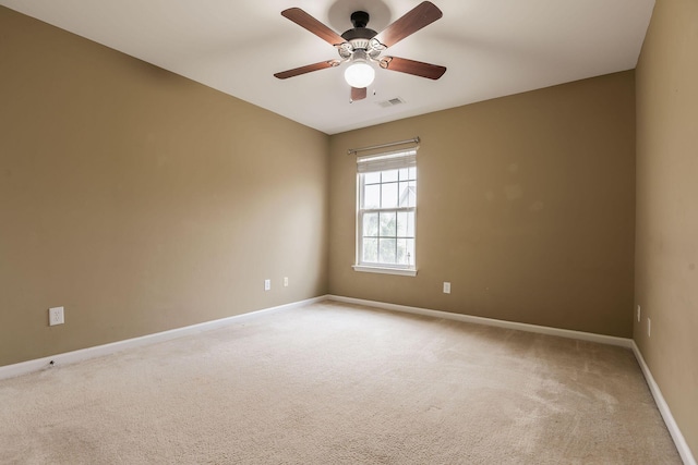 unfurnished room with carpet flooring, a ceiling fan, visible vents, and baseboards