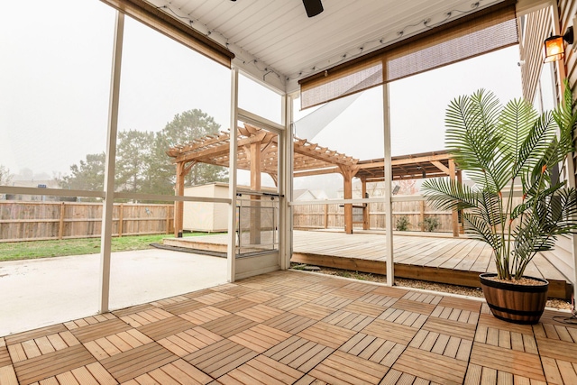 unfurnished sunroom with a ceiling fan