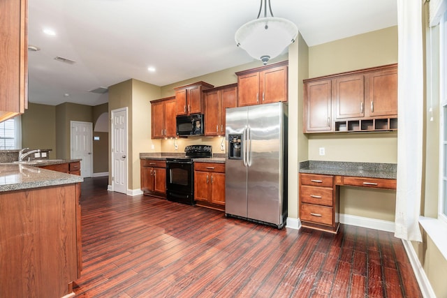 kitchen with visible vents, black appliances, brown cabinets, dark wood-style floors, and built in study area