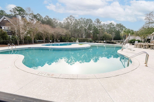 community pool featuring a patio and fence