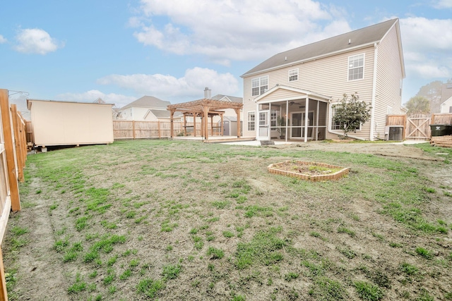 rear view of house featuring an outbuilding, a pergola, a fenced backyard, and a sunroom