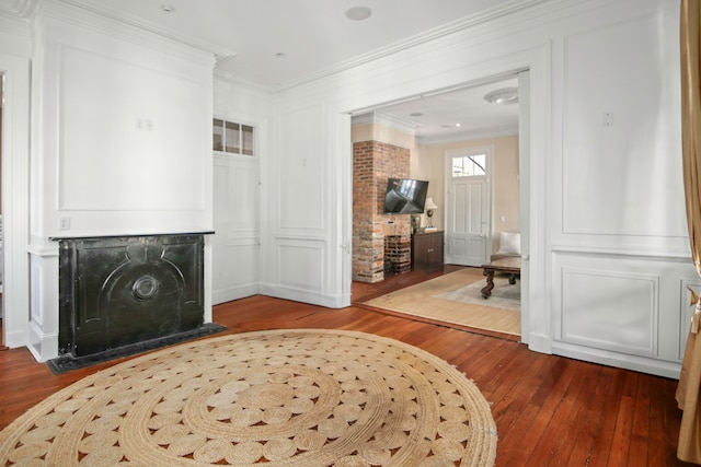 interior space with a high end fireplace, ornamental molding, and dark hardwood / wood-style floors